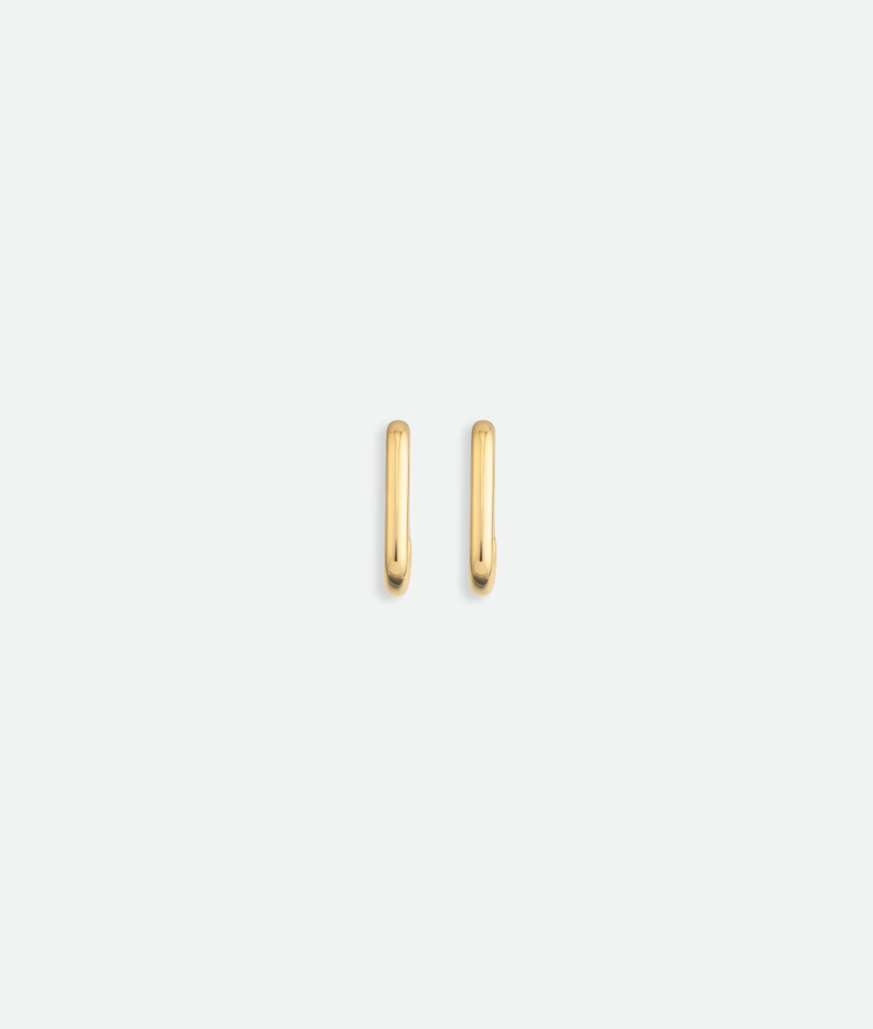 Gold hoop earrings on a light beige background