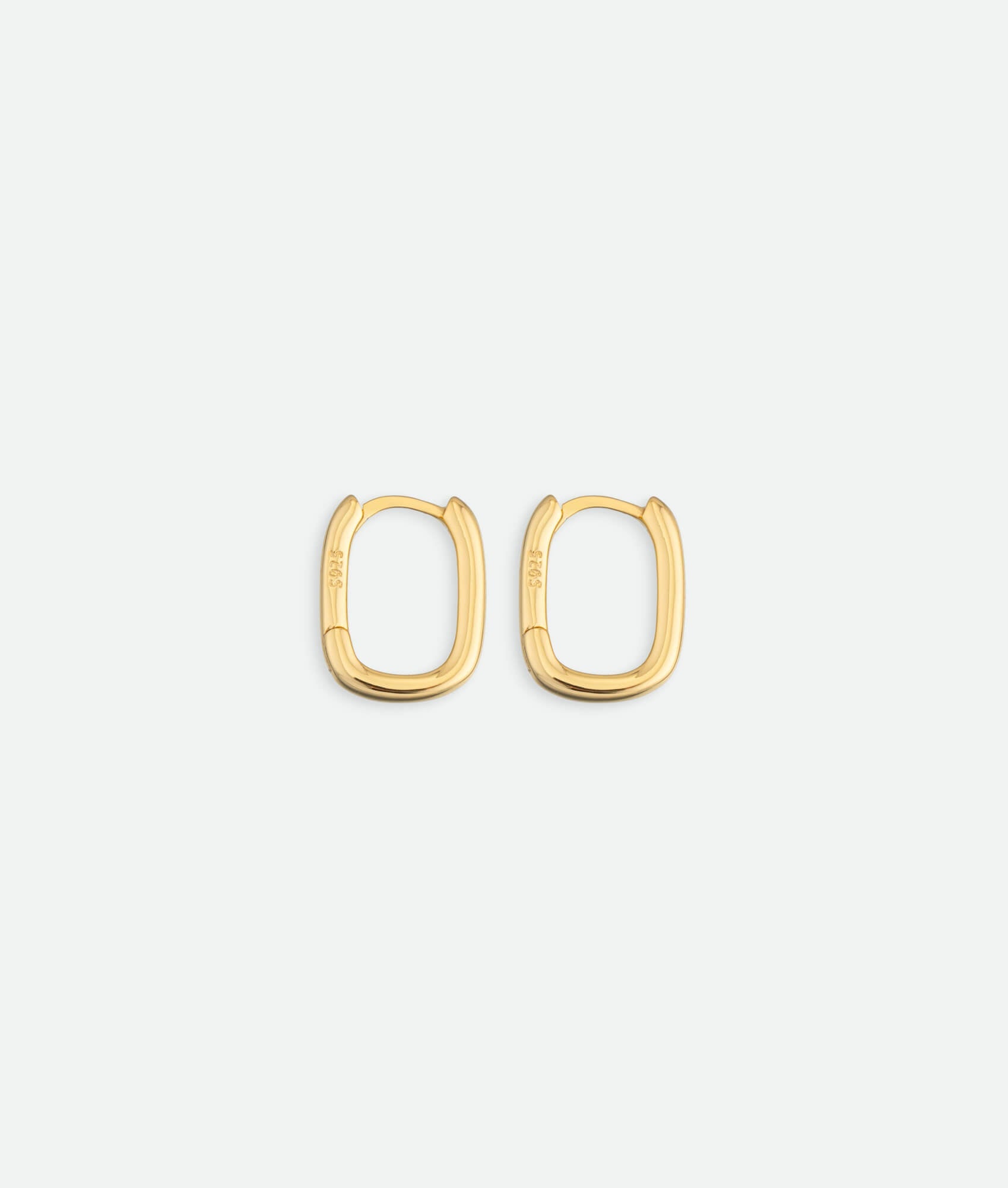 Gold hoop earrings on a light gray background