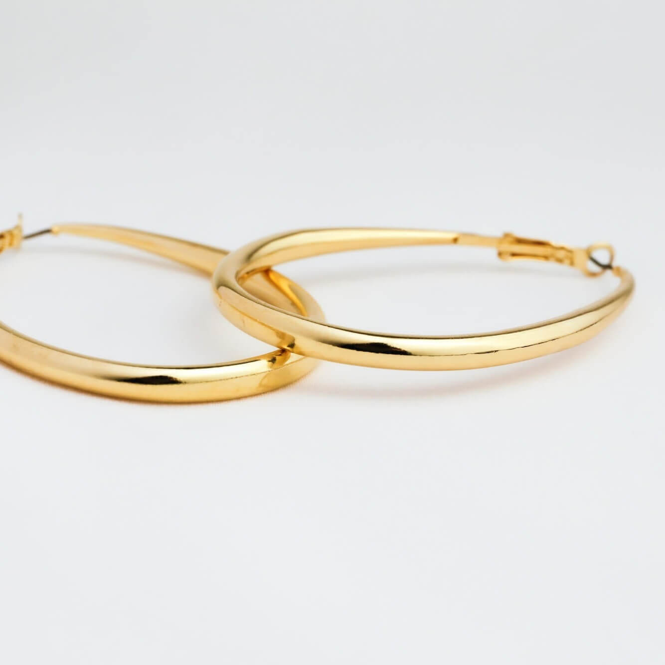Gold hoop earrings on a light gray background