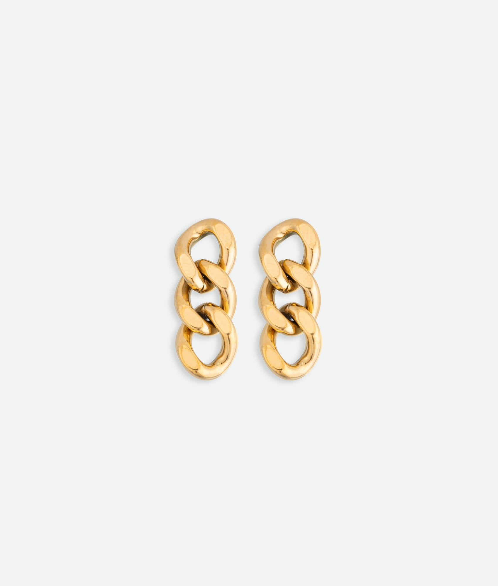 Pair of gold chain link earrings on a white background