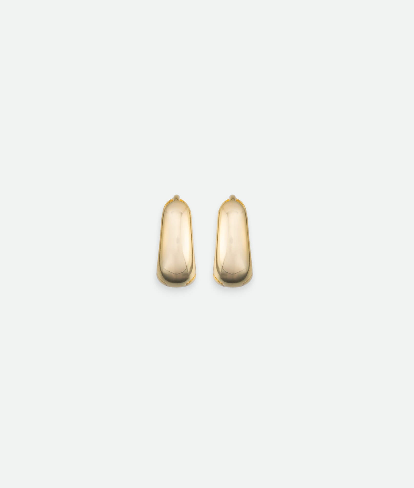 Pair of gold hoop earrings on a light gray background