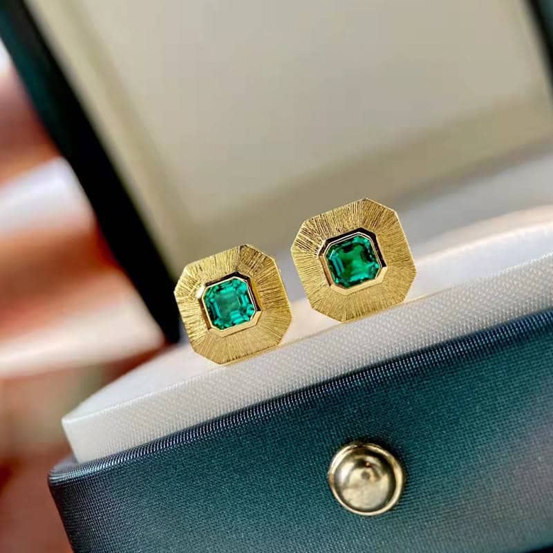 Gold stud earrings with emerald