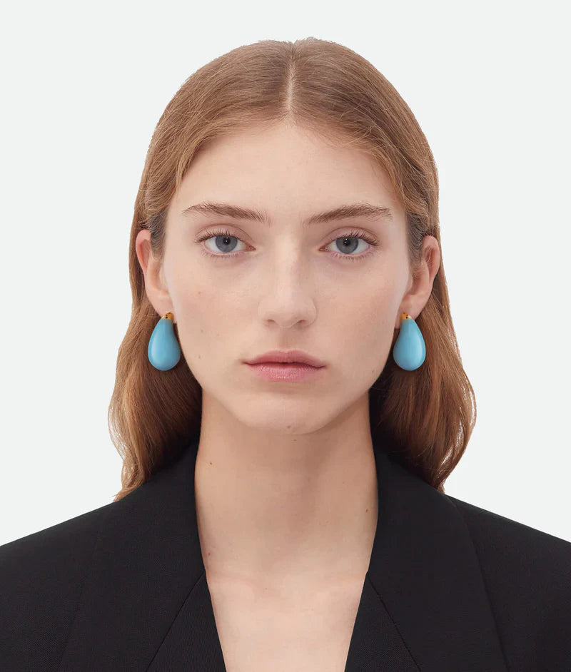 Model wearing big blue drop earrings