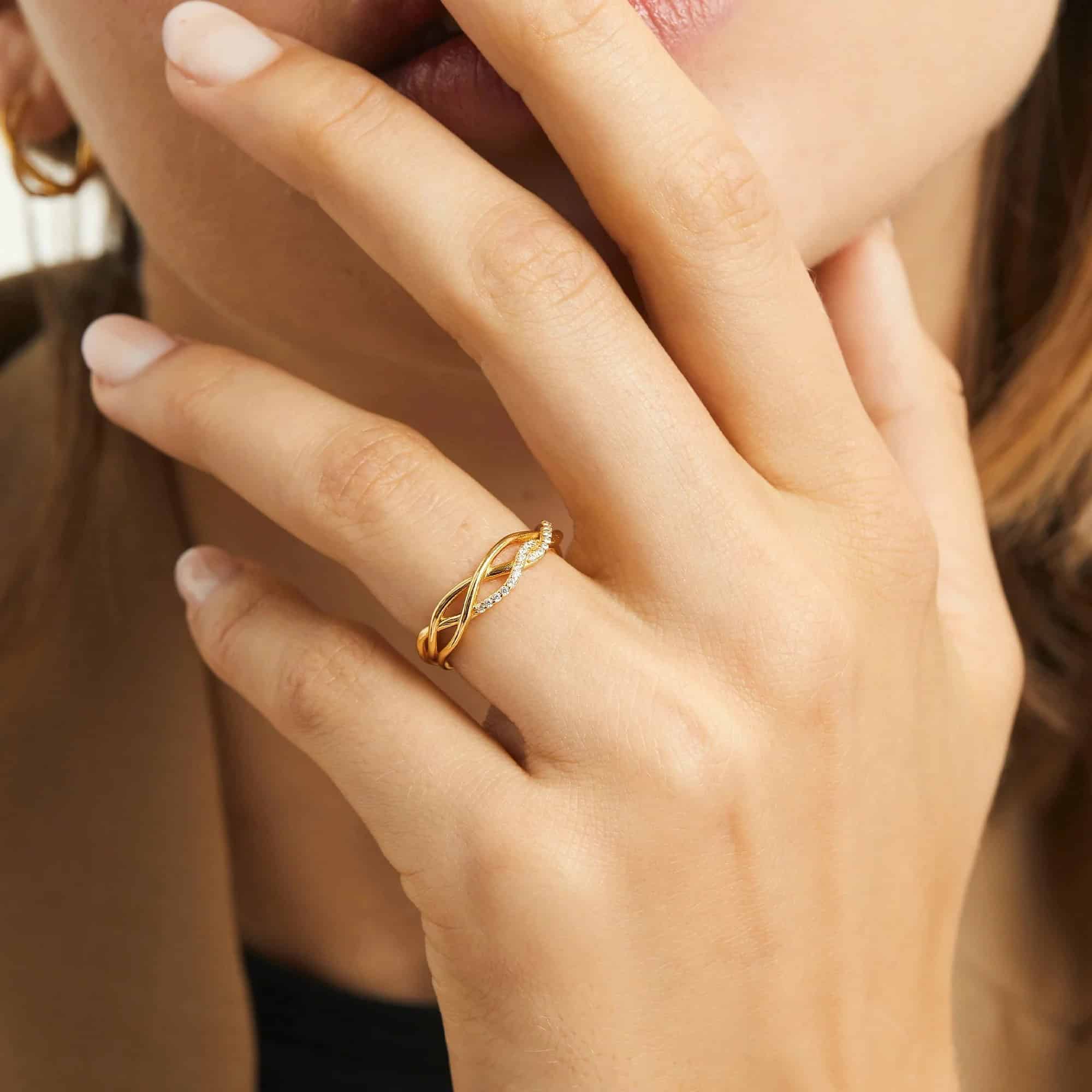 Model wearing gold wave ring with zircon