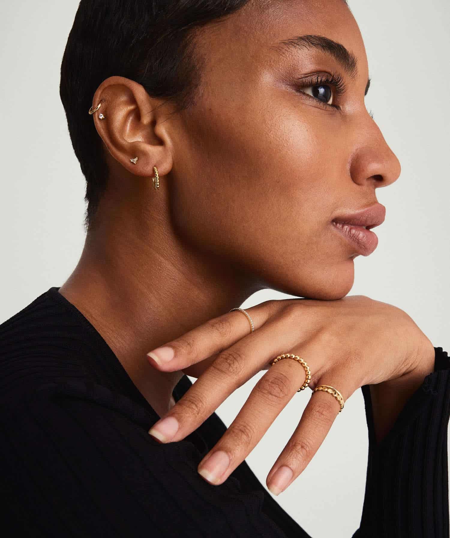 Model wearing Gold Beaded Huggie Hoops Earrings