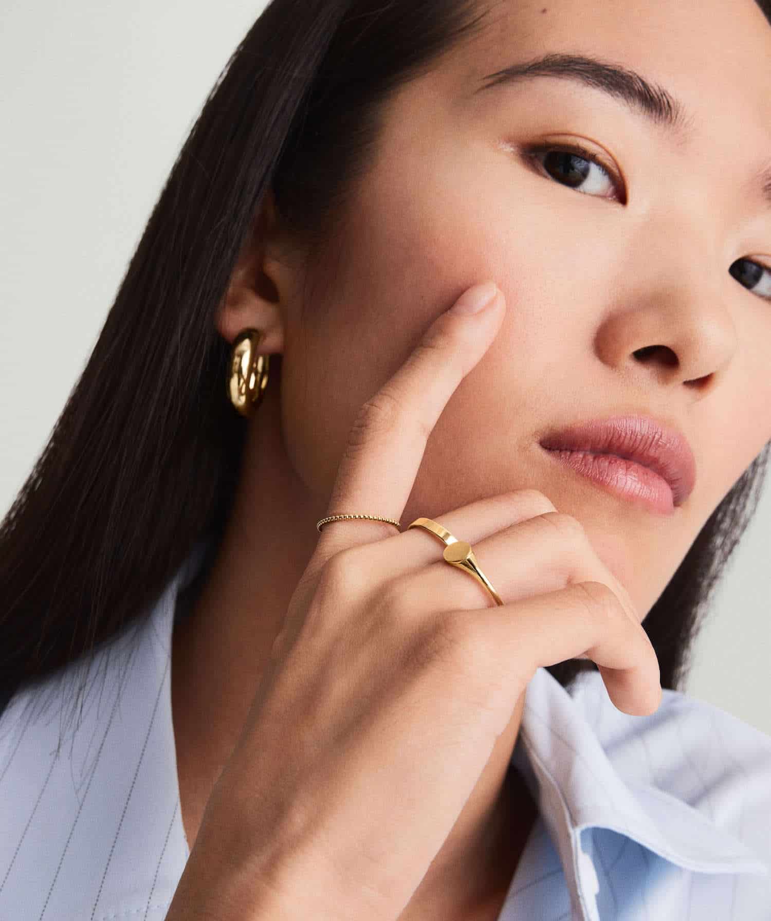 Model wearing gold jewelry