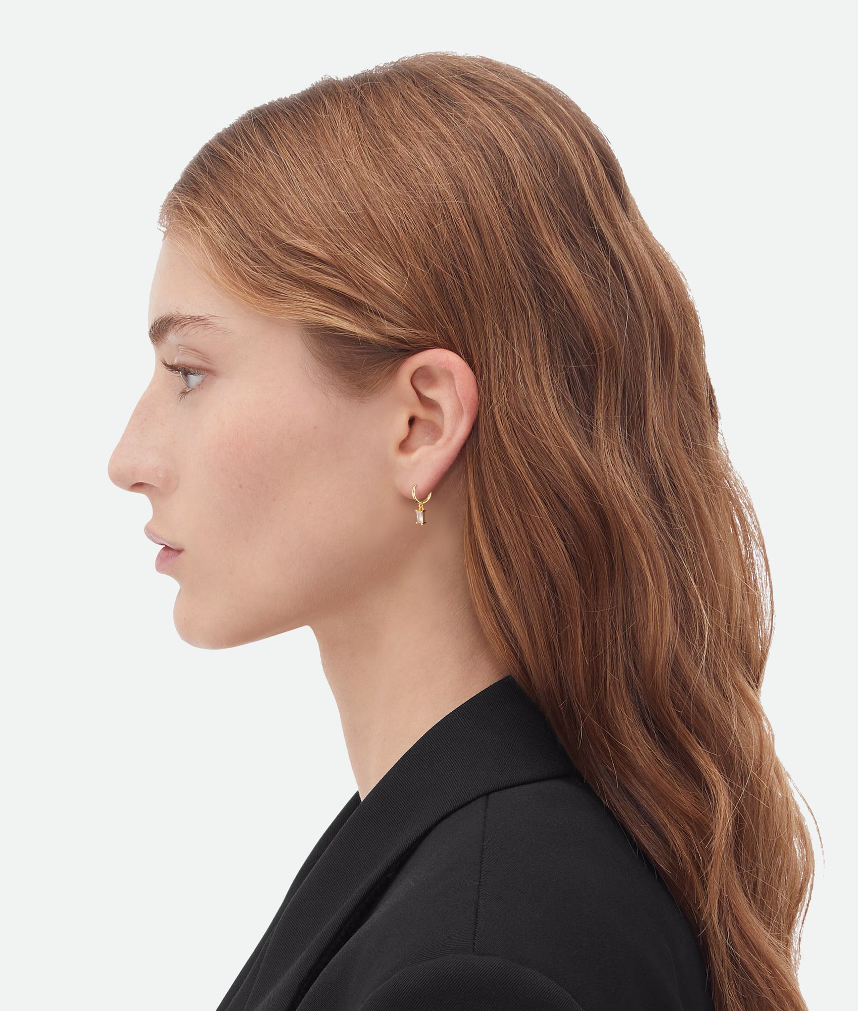 Model wearing recatngular zircon charm earrings in gold