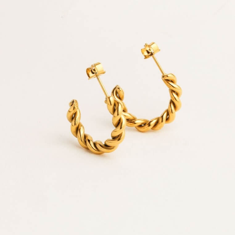 Gold hoop earrings on a light beige background