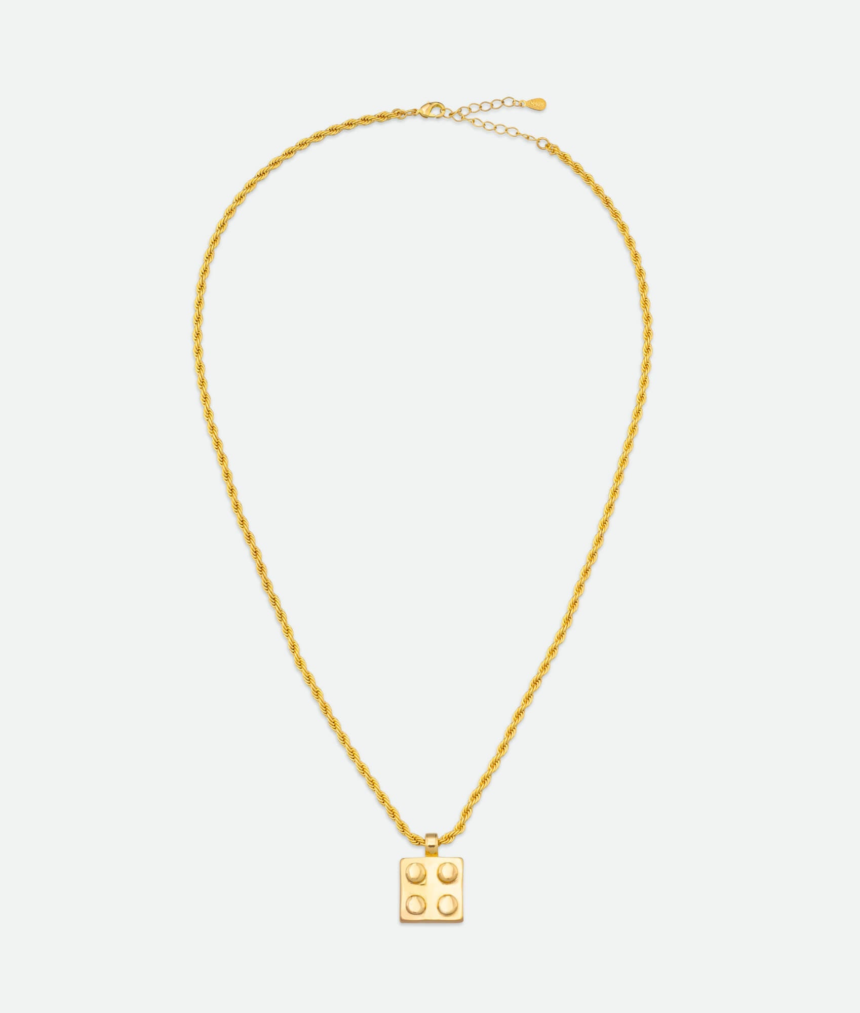 Gold necklace with a square pendant on a light gray background