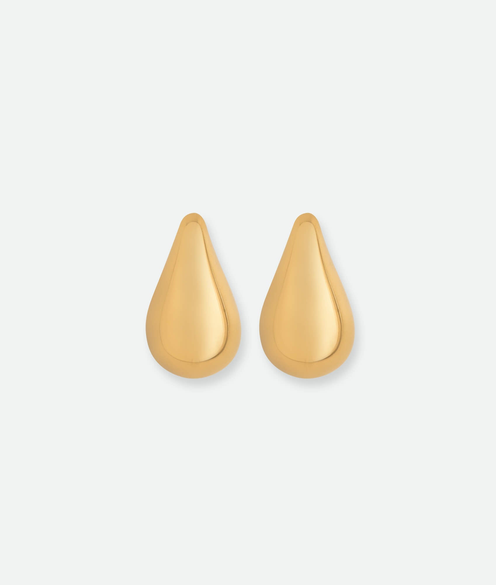 Gold teardrop earrings on a light gray background