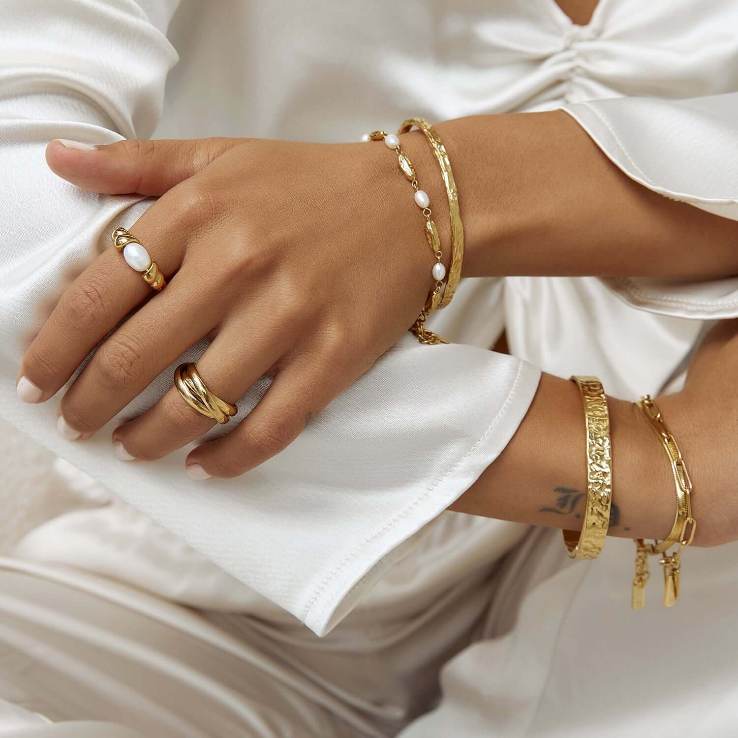 Model wearing gold rings and bracelets