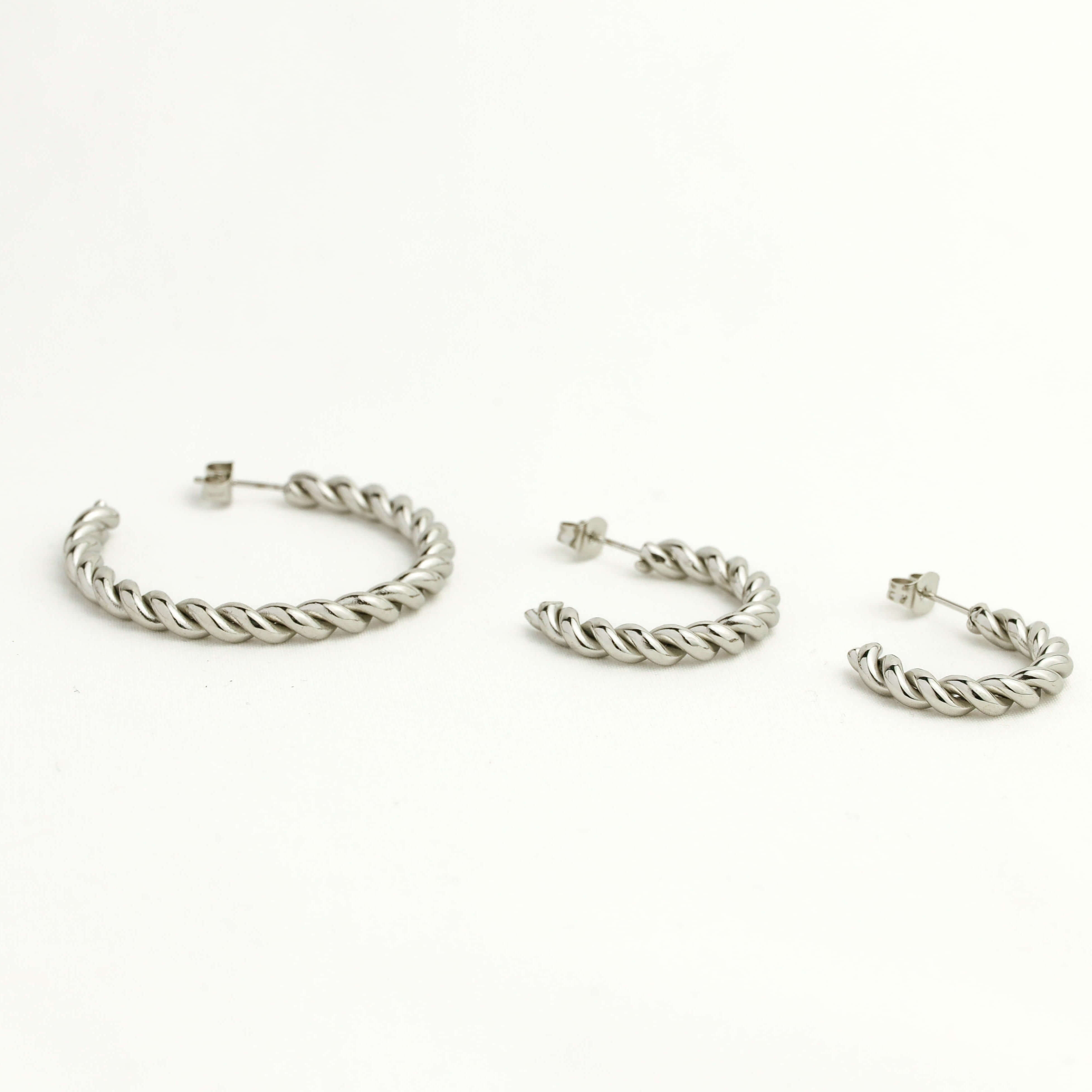 Set of silver hoop earrings on a white background