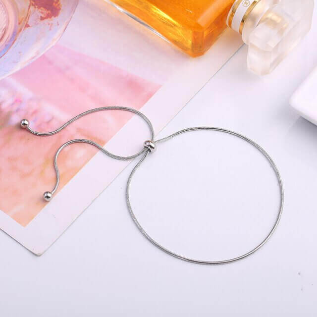 Silver necklace with beads on a light surface