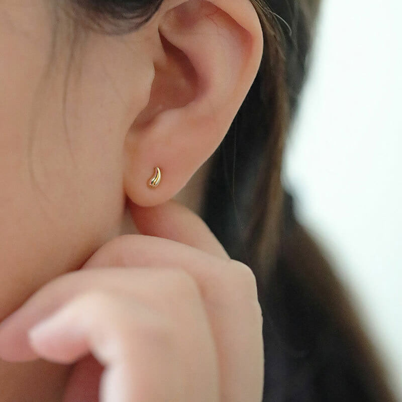 Model wearing Mismatched Gold Stud Earrings