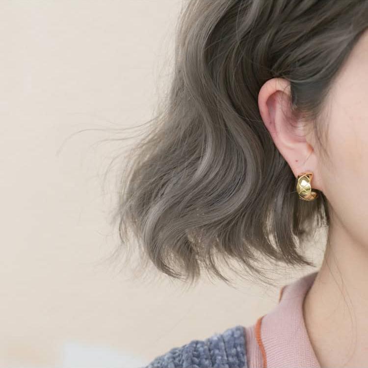 Model wearing Criss-cross Patterned Earrings Gold