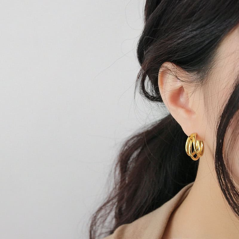 Model wearing gold Tri-Layered Hoop Earrings