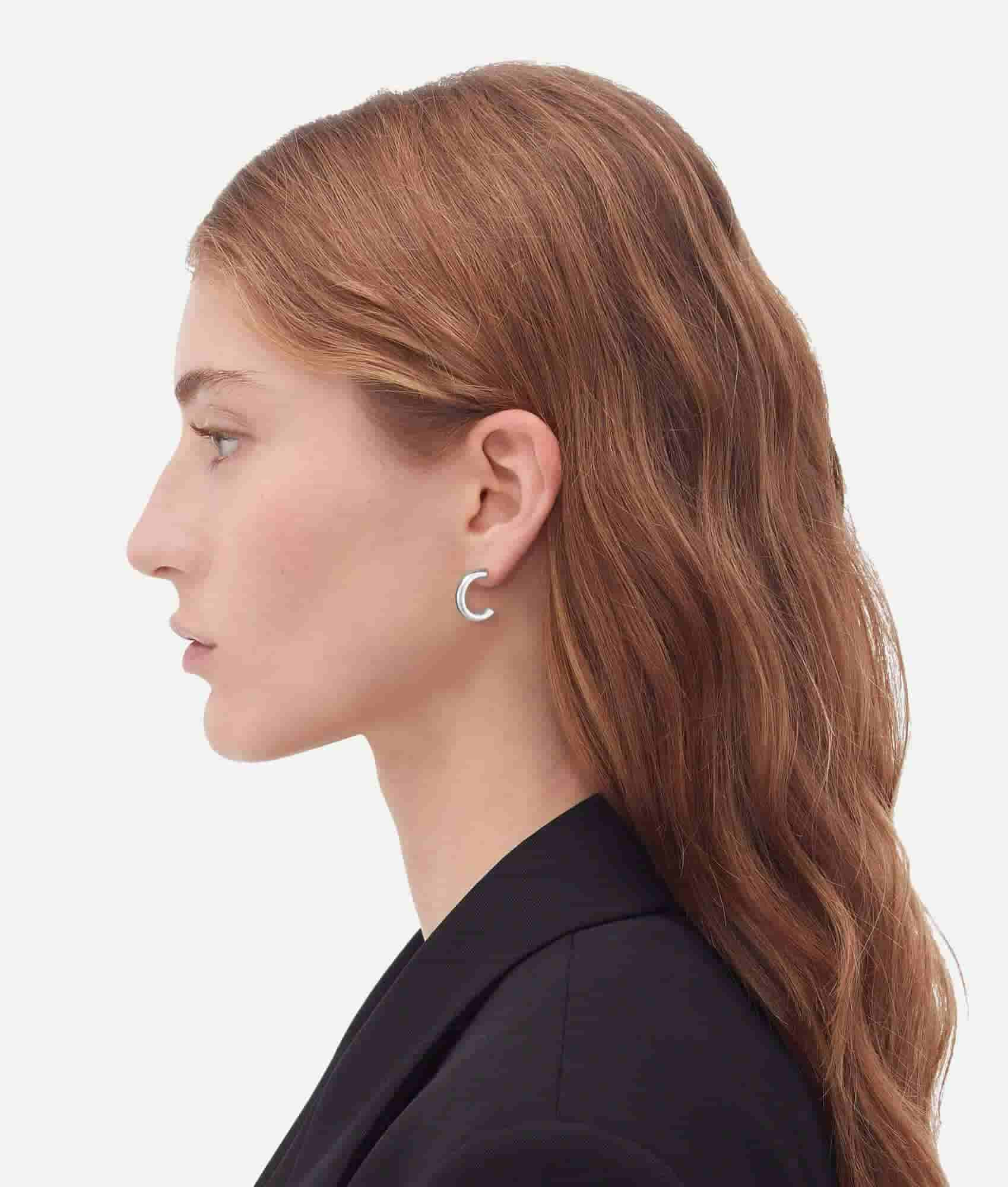 a women model wearing silver hoop ear rings