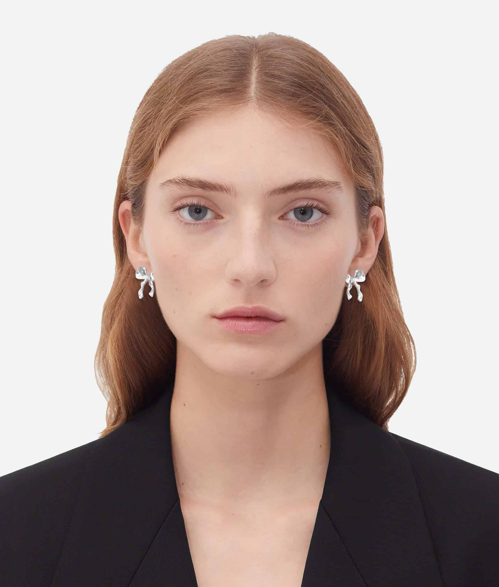 a woman wearing silver Statement Bow Earrings